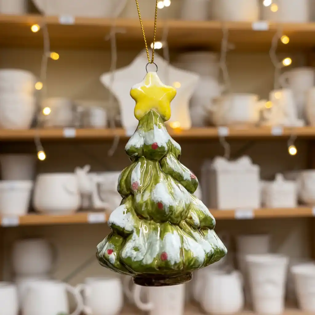 Ceramic Christmas tree ornament with snowy branches and a gold star